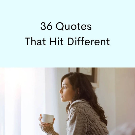 Woman looking out a window with a curtain, holding coffee mug.