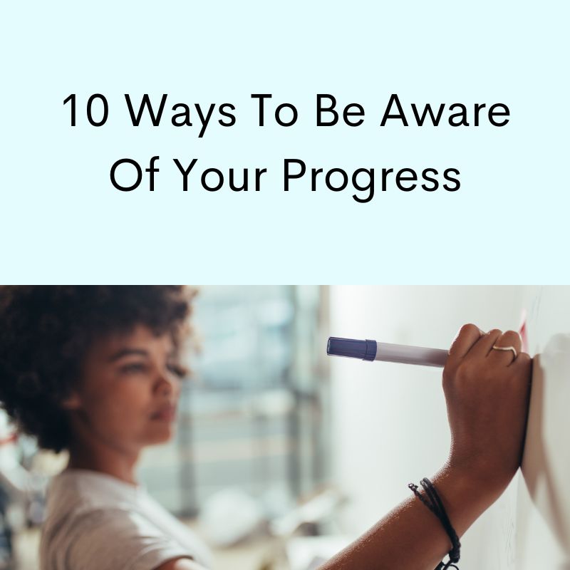 Multi-ethnic woman, curly hair writing on white board with pen.